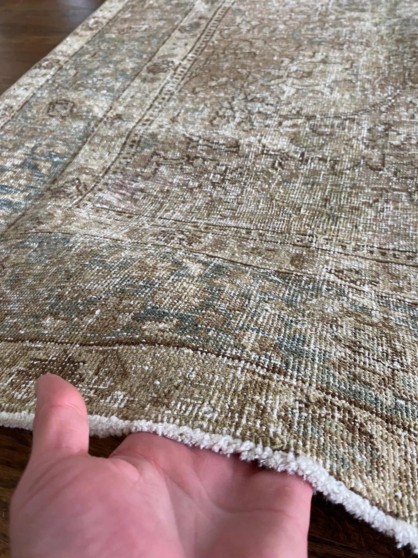 Close up antique Tabriz rug showing texture and wear
