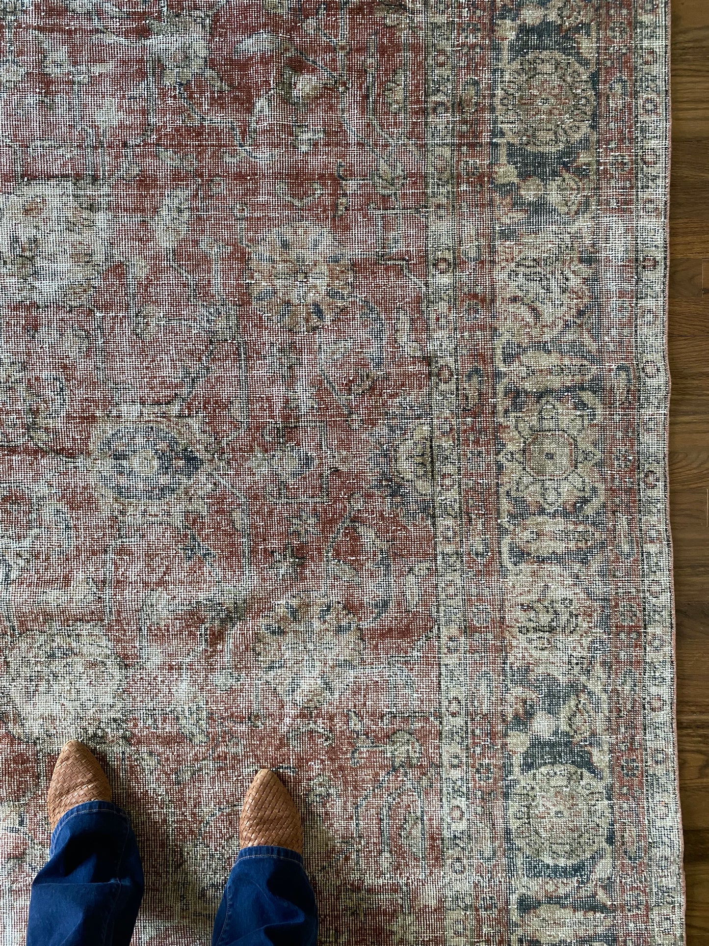 Muted red vintage rug floral pattern detail.