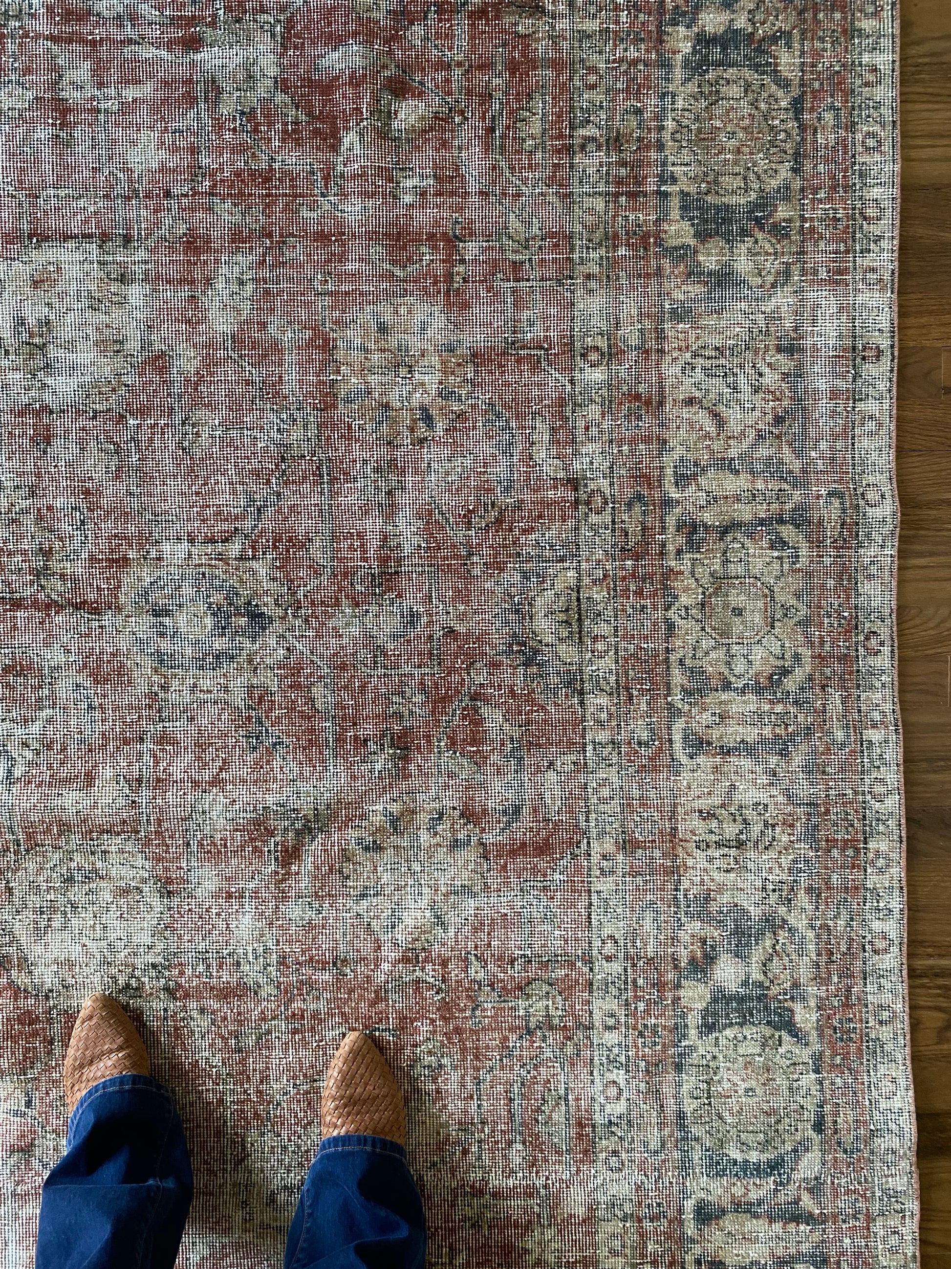 Muted red vintage rug floral pattern detail.